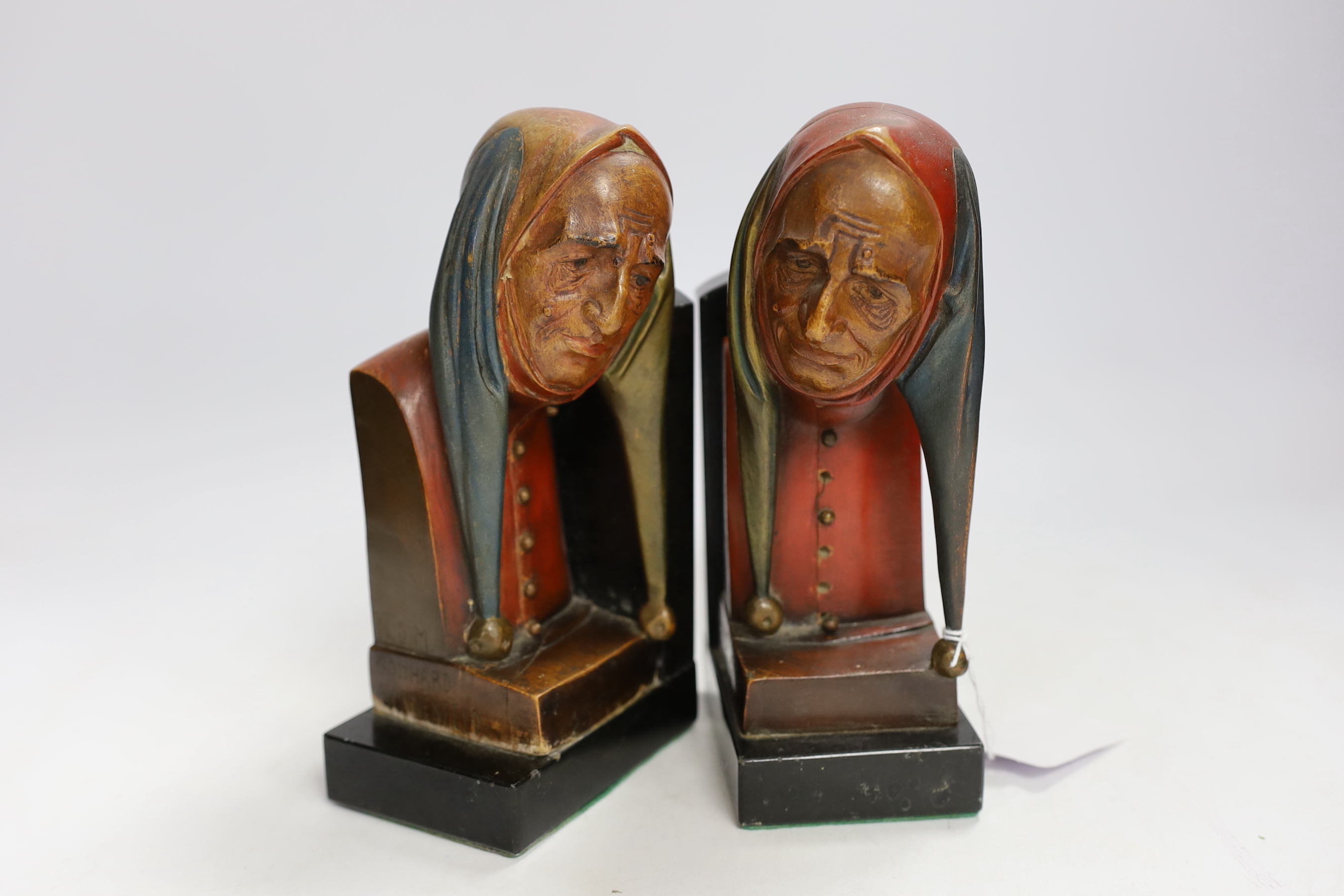 A pair of Gotthard Sonnenfeld painted wood bookends, granite bases, engraved, N.D.M, both with busts of jesters, 20cm high